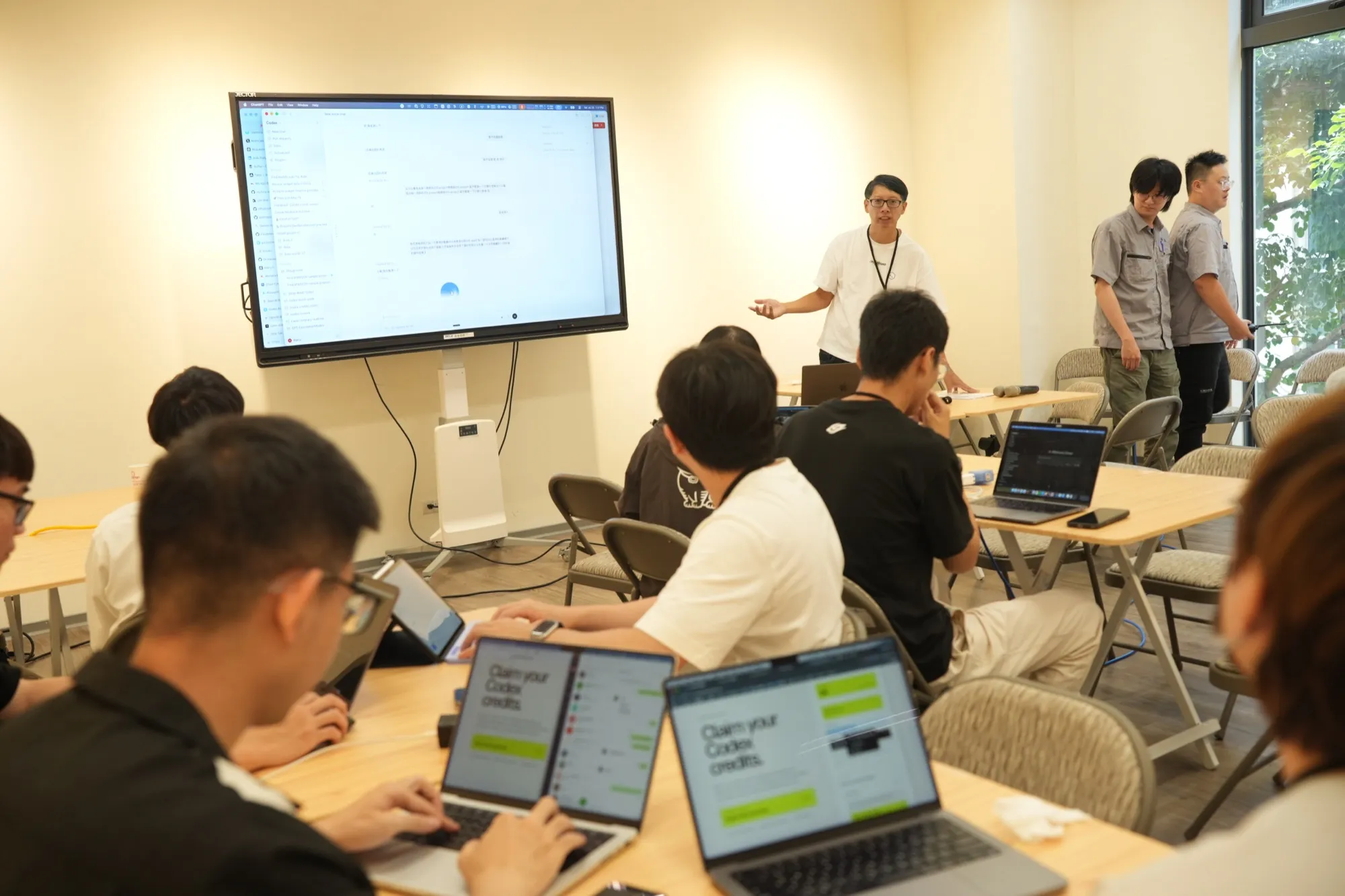 參與者帶著筆電在 AI 工具實作工作坊一起操作與討論