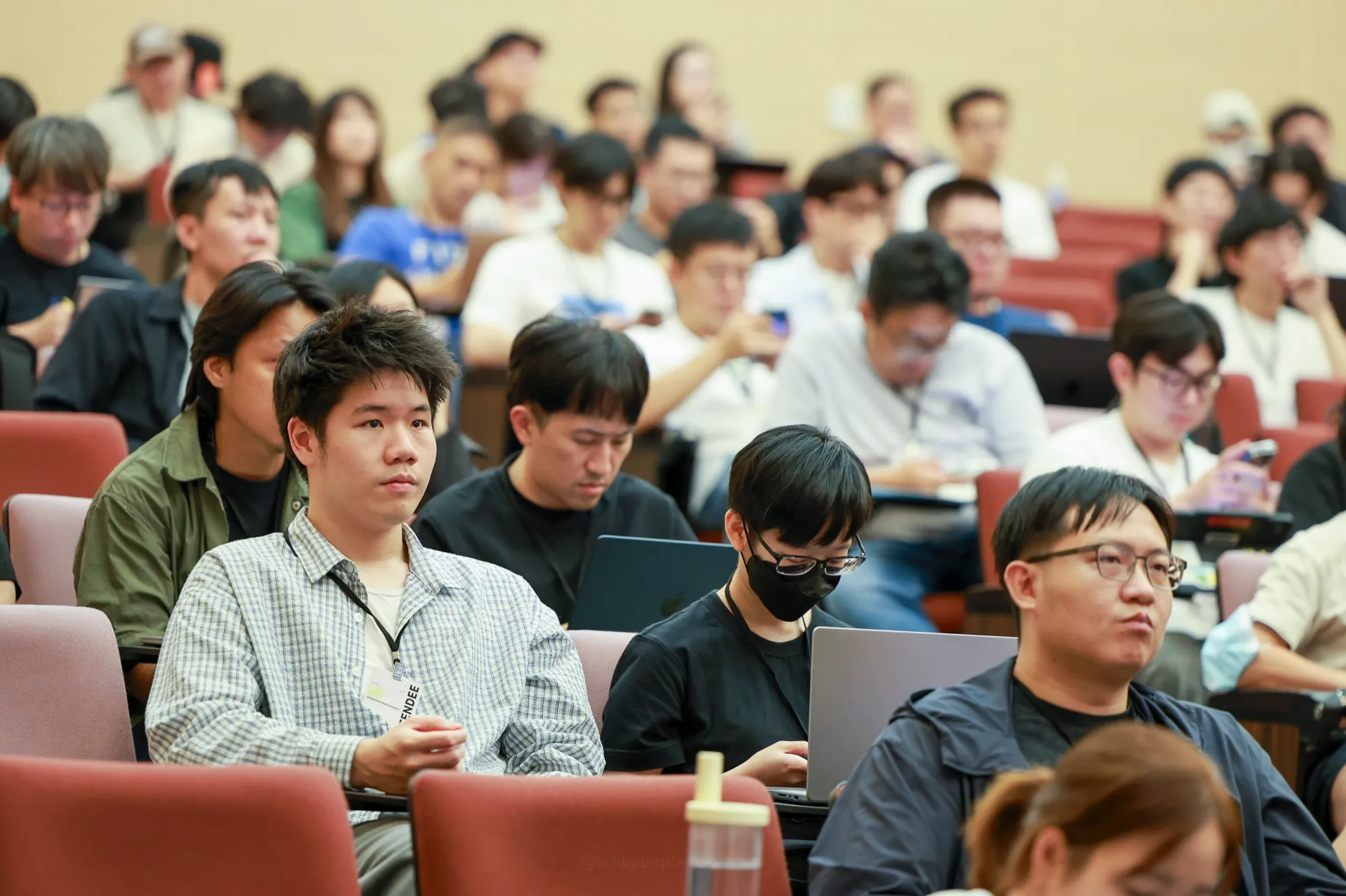 iPlayground 2026 Day 1 會眾坐滿階梯教室，專注聆聽並使用筆電記錄